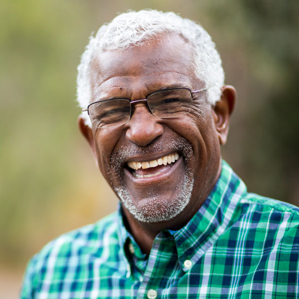 elderly man with glasses smiling